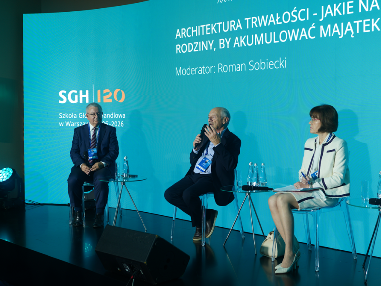 trzy osoby rozmawiają na scenie na panelu