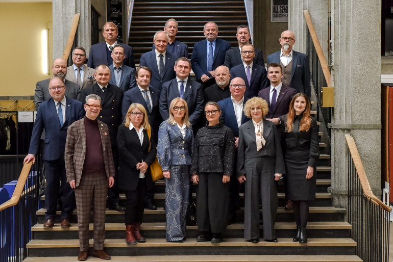 Grupa ludzi stojących na schodach w kilku rzędach