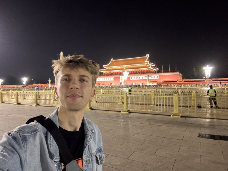 zdjęcie mężczyzny na tle oświetlonej pagody