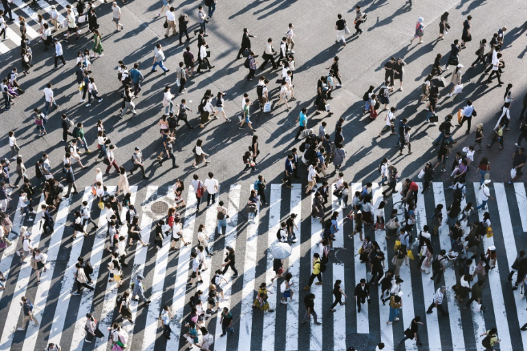 grupa osób przechodzi przez przejście dla pieszych i przez ulicę; Fot. Ryoji Iwata, Unsplash